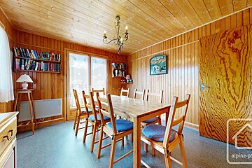 A dining room with a table and chairs and a sign on the wall that says montagne