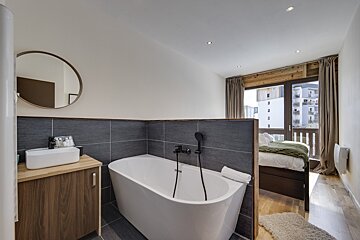 A bathroom with a bathtub a sink and a mirror