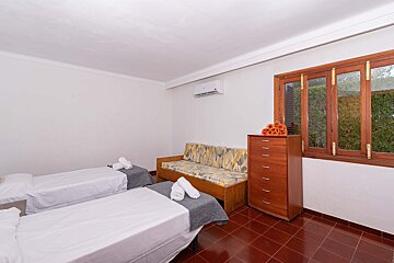 A bedroom with two beds a couch and a dresser