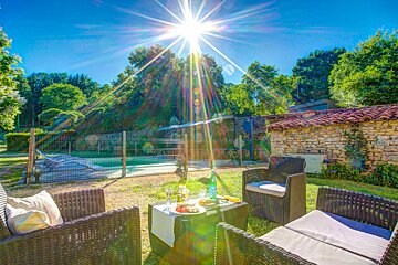 The sun shines brightly over a patio area with wicker furniture