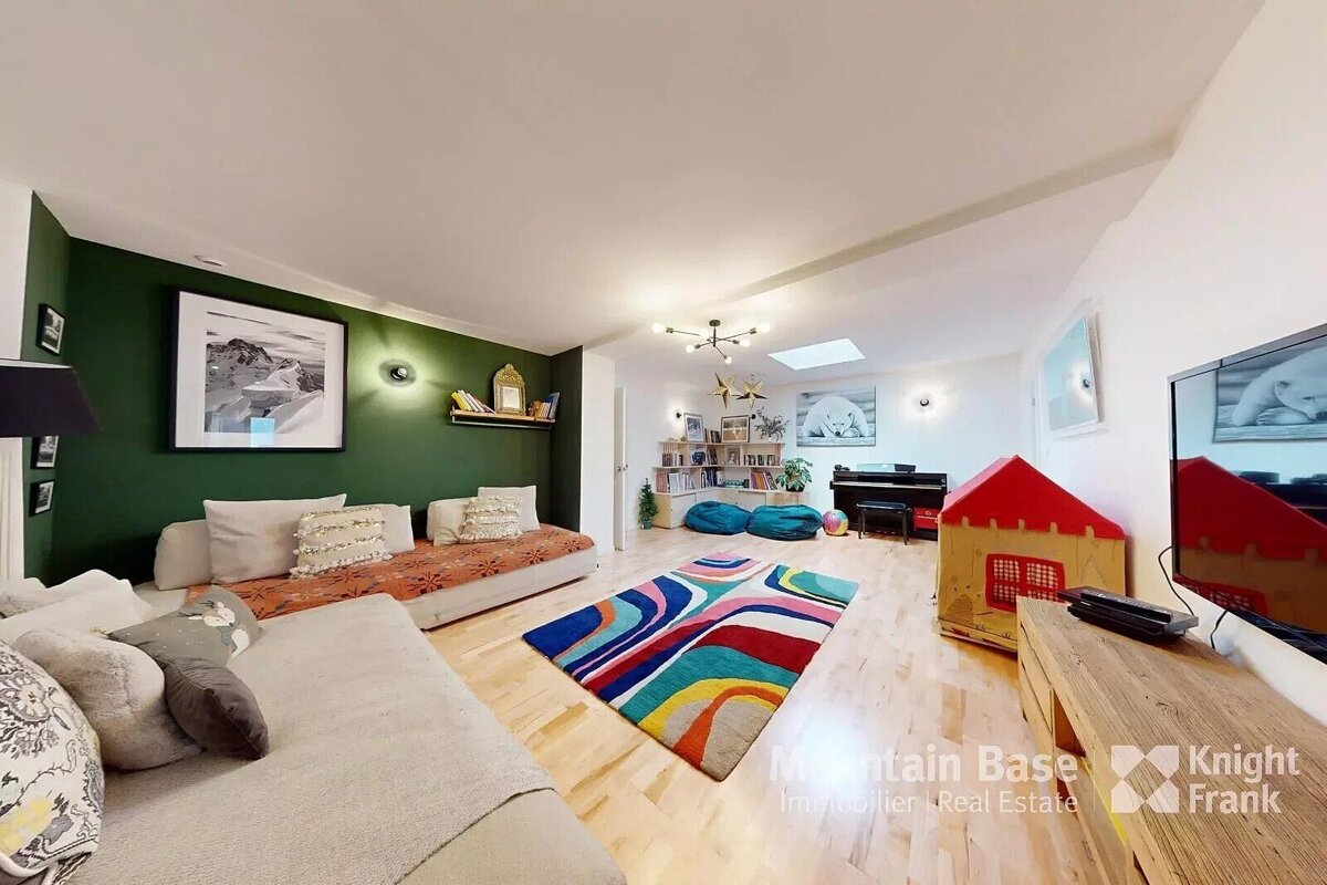 A living room with a couch a rug and a television sponsored by knight frank