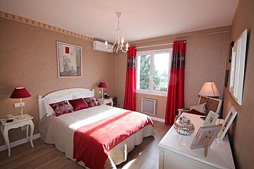 A bedroom with a large bed and red curtains