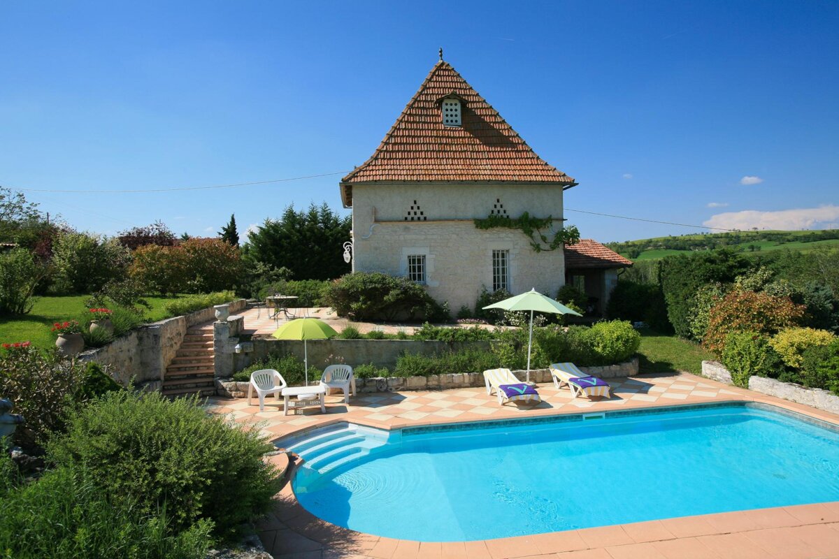 A large house with a swimming pool in front of it