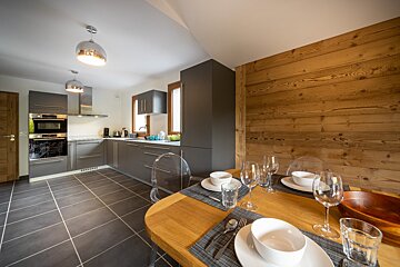 A kitchen with gray cabinets and a wooden wall