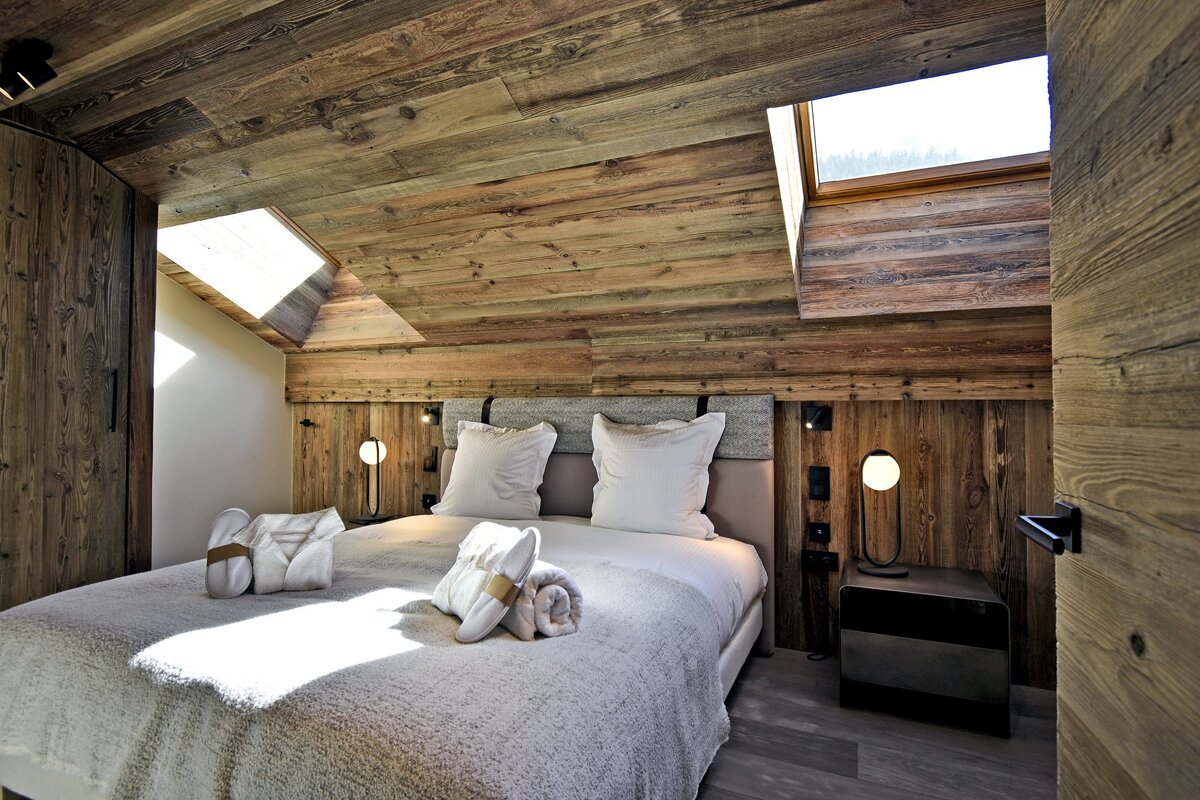 A bedroom with a large bed and a skylight