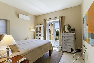 A bedroom with a dresser and a painting on the wall