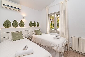 A bedroom with two twin beds and a window