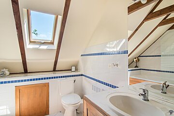 A bathroom with a skylight above the toilet