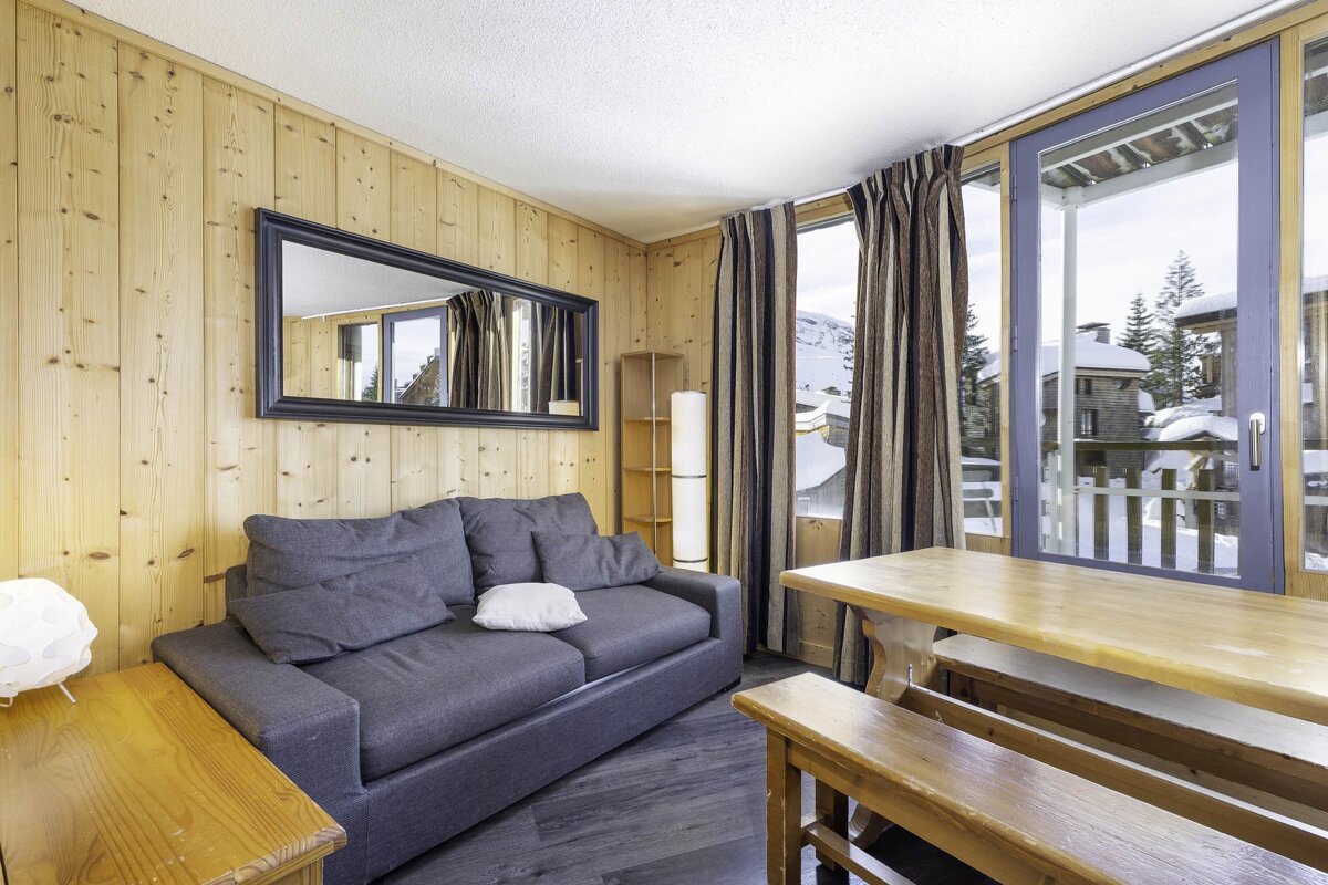 A living room with a couch a table and a mirror