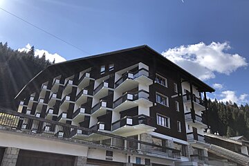 A large building with cars parked in front of it and a sign that says ' a ' on it