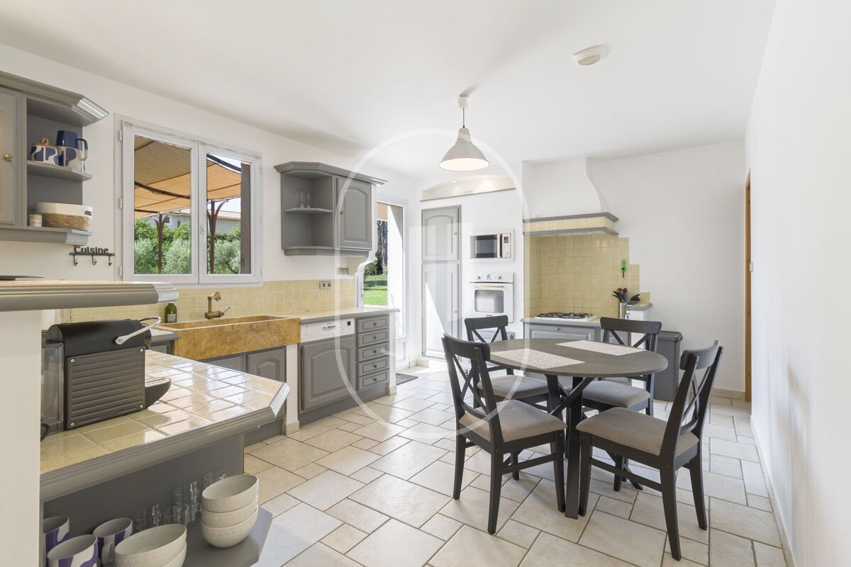 A kitchen with a table and chairs and a sink