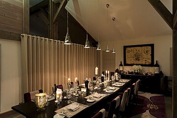 A dining room with a long table and candles on it