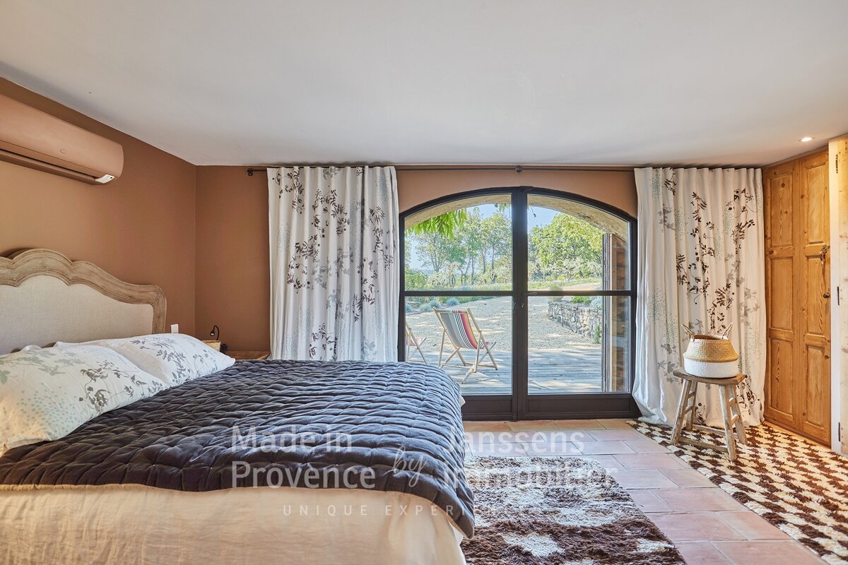 A bedroom with a bed and a window that says made in provence