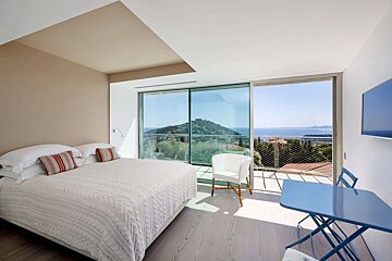 A bedroom with a large bed and a view of the ocean
