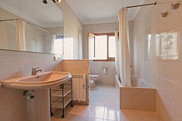 A bathroom with a sink a toilet and a window