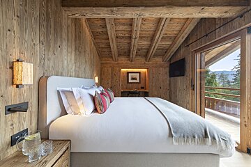 A bedroom with wooden walls and a large bed