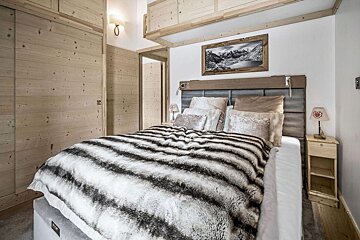 A bedroom with a bed and a picture on the wall