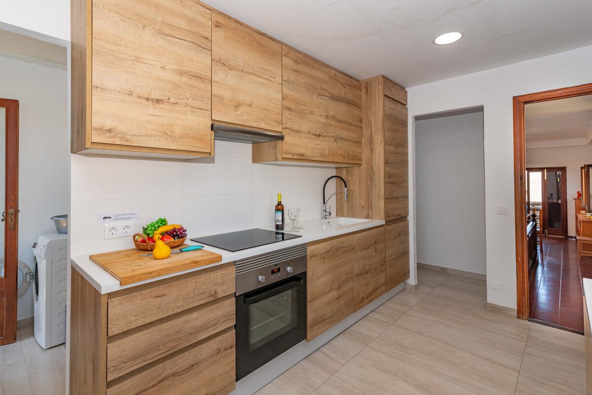 A kitchen with wooden cabinets and a bottle of wine