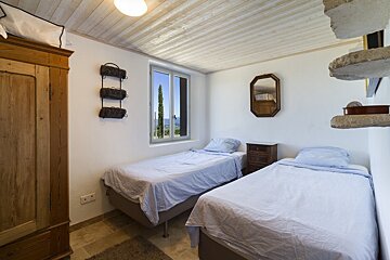 A bedroom with two beds and a mirror on the wall