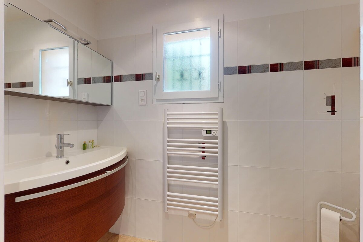 A bathroom with a sink and a towel warmer