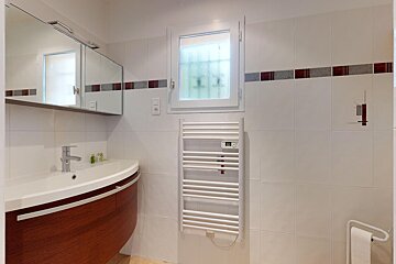 A bathroom with a sink and a towel warmer