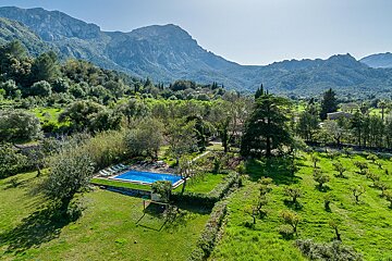 An aerial view of a swimming pool with mountains in the background