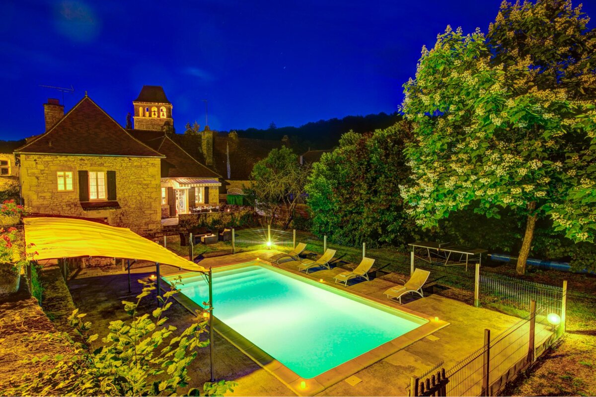 A large swimming pool is lit up at night
