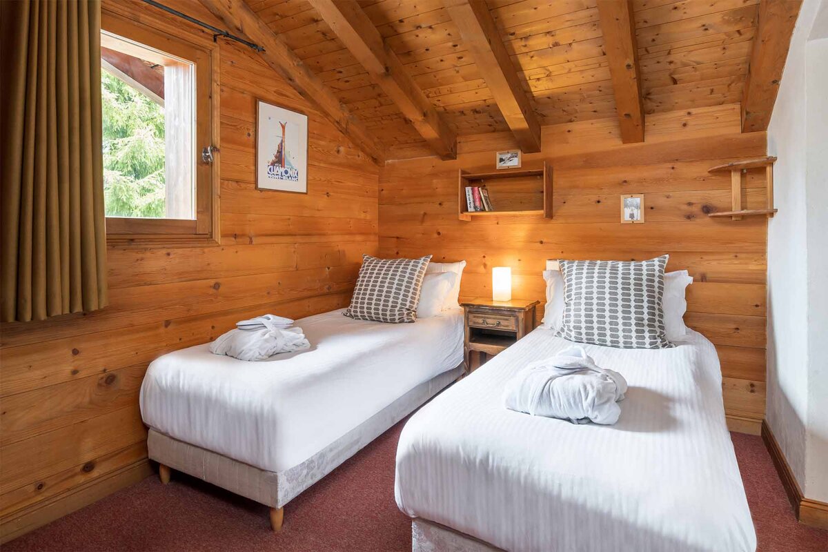 A bedroom with two twin beds and a picture on the wall