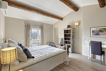 A bedroom with a large bed and a picture on the wall