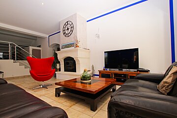A living room with a fireplace and a clock on the wall