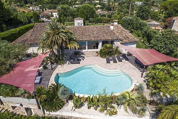 An aerial view of a house with a large swimming pool