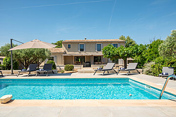 A large house with a swimming pool in front of it