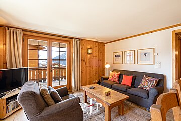A living room with a couch a chair and a table with jp written on it