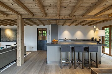 A kitchen with a bowl of oranges on the counter