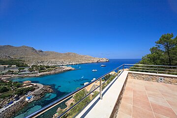 A balcony overlooking a body of water with mountains in the background