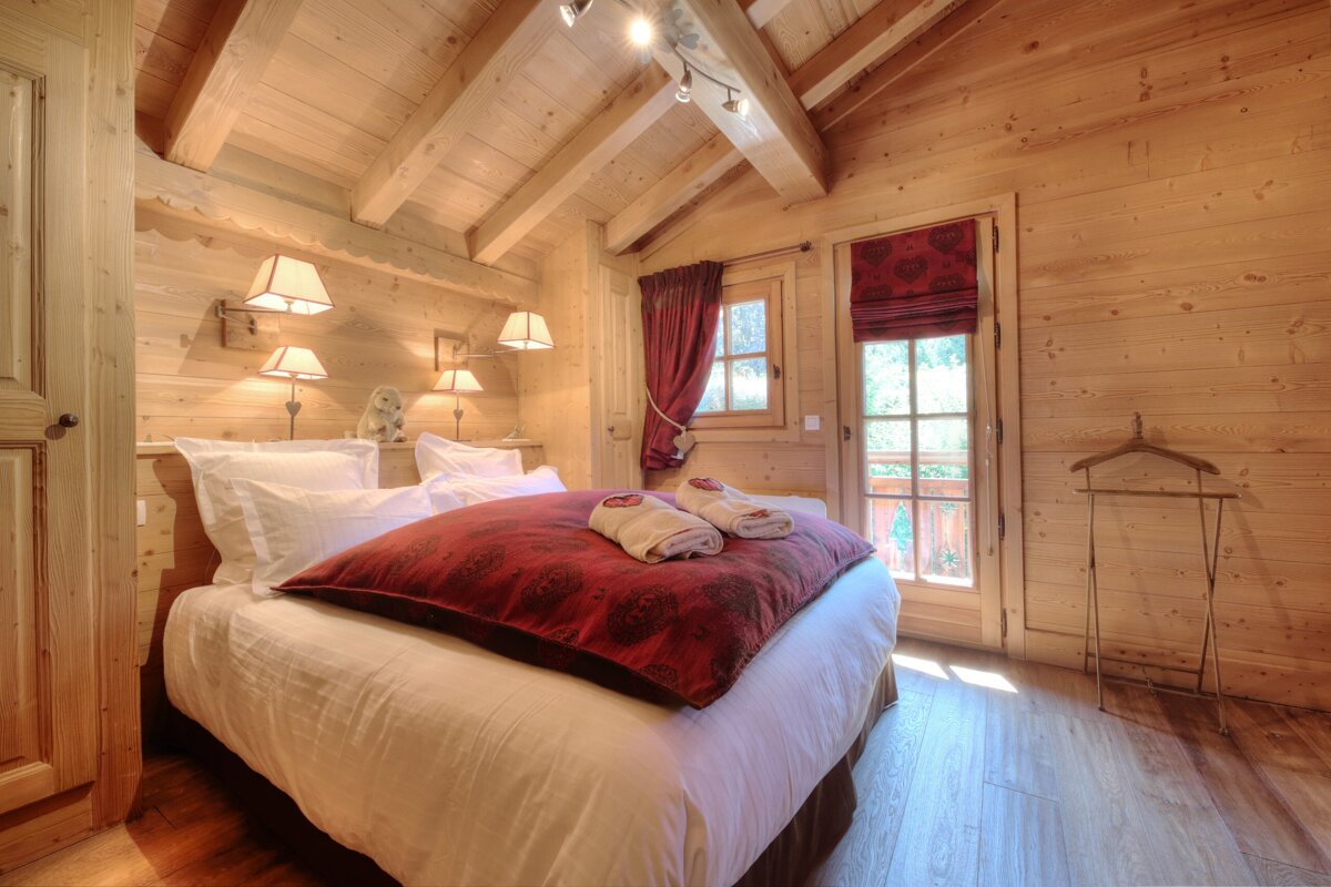 A wooden bedroom with a bed and a window