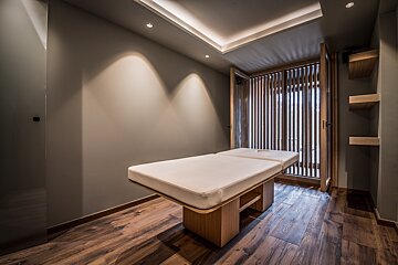 A massage table in a room with wooden floors