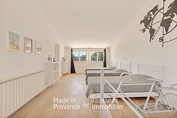 A bedroom with three beds made in provence by immobilier