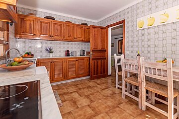 A kitchen with wooden cabinets and a table and chairs