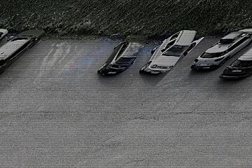 A row of cars are parked in a parking lot and one of them has the word police on it
