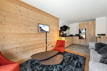 A living room with wood paneling and a flat screen tv