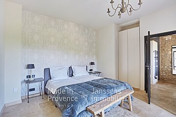 A bedroom with two beds and a bench made in provence