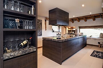 A bottle of wine sits on a counter in a kitchen
