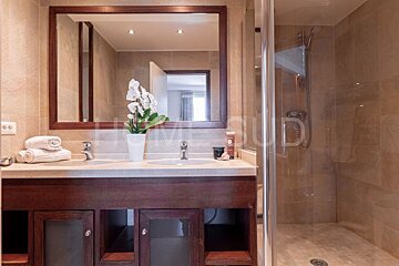 A bathroom with two sinks and a large mirror with the word sud on the bottom