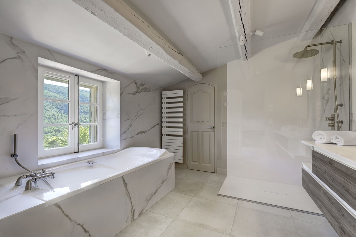 A bathroom with a bathtub and a window