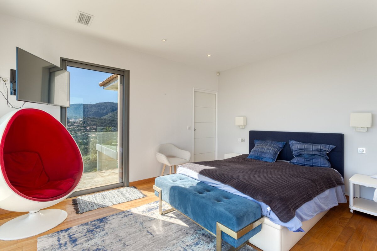 A bedroom with a large bed and a red chair