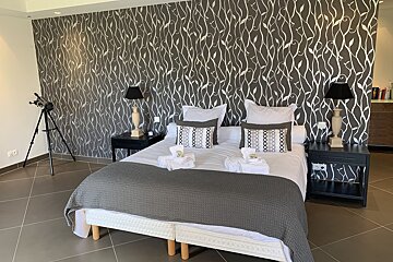 A bedroom with a black and white wallpaper on the wall