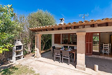 A patio with a table and chairs and a bbq