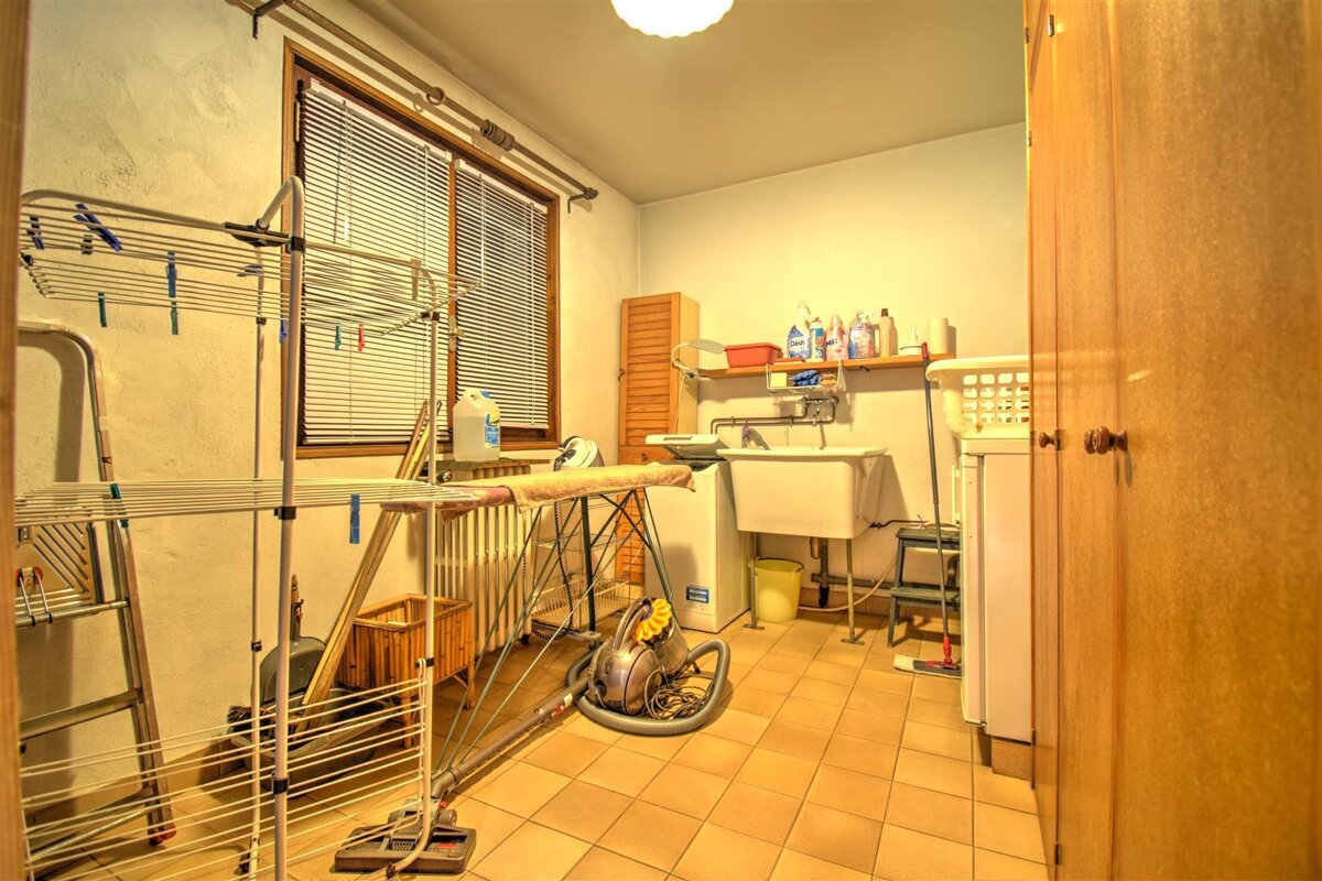 A laundry room with a washing machine and a vacuum cleaner