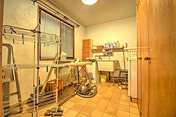 A laundry room with a washing machine and a vacuum cleaner
